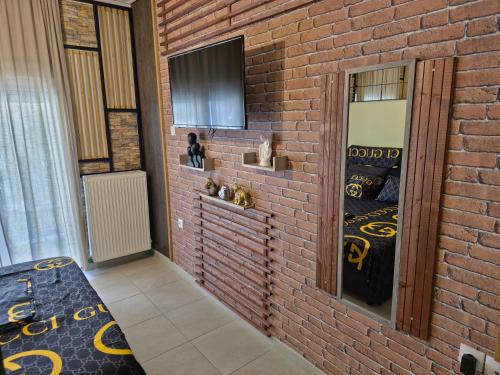 a room with a brick wall with a bed and a mirror at GpxClrTheStreetFashionSuiteNW in Larisa