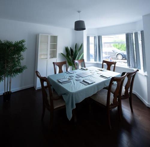 a dining room with a table with chairs and a table cloth at Spacious 3 Bed Home Manchester Airport Free Parking in Manchester