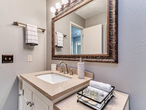 a bathroom with a sink and a mirror at Parkside Getaway- Spacious Six Bedroom Home for Families & Friends in Ames
