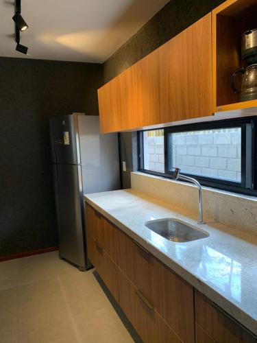 a kitchen with a sink and a refrigerator at Patacho Porto Gamboa in Pôrto de Pedras