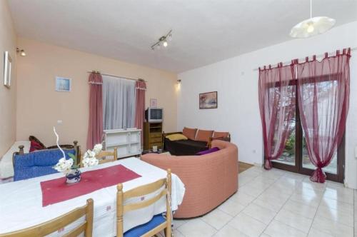 a living room with a table and a couch at Apartment Zvone in Sumpetar
