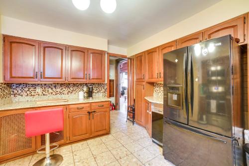a kitchen with wooden cabinets and a stainless steel refrigerator at Spacious Pittsburgh Rental Walk to Frick Park! in Pittsburgh