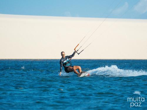 a man on a surfboard in the water at Muita Paz in Atins