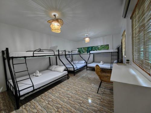 a room with three bunk beds and a tub at 5R Tourist Inn & Restaurant in Pooc