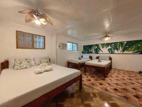a bedroom with two beds and two tables in it at 5R Tourist Inn & Restaurant in Pooc