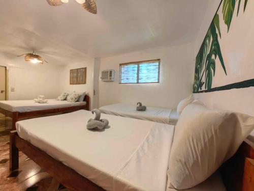 a room with two beds and two swans sitting on them at 5R Tourist Inn & Restaurant in Pooc