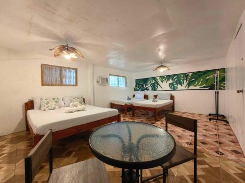 a room with two beds and a table in it at 5R Tourist Inn & Restaurant in Pooc