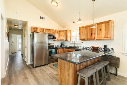 a kitchen with wooden cabinets and a stainless steel refrigerator at Breathtaking Island Views from Multiple Decks! in Surfside Beach