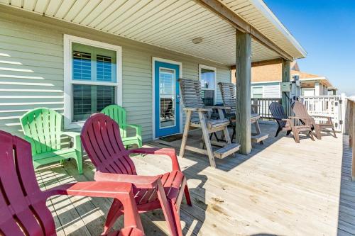 a deck with colorful chairs and tables on a house at Breathtaking Island Views from Multiple Decks! in Surfside Beach