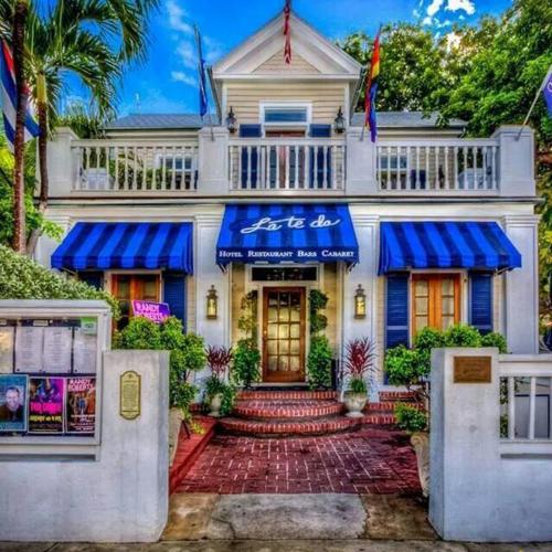 a white house with a blue awning at La Te Da - Adult Only, 21 or older in Key West