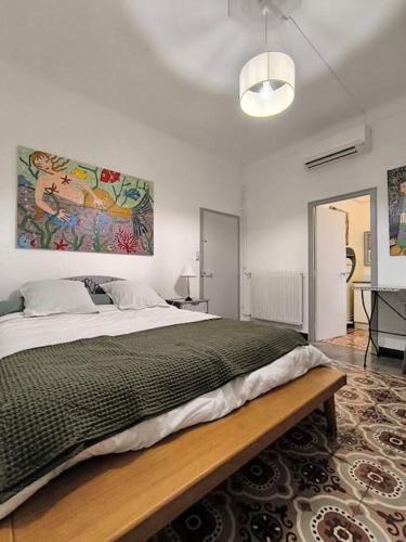 une chambre avec un grand lit et un tableau au mur dans l'établissement Appartement charmant et lumineux, à Perpignan