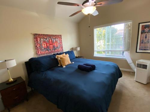 a bedroom with a blue bed and a ceiling fan at Family friendly 3 story townhouse with workspace in Beaverton