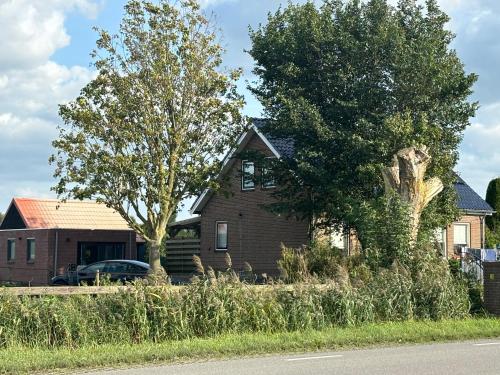 a house with a car parked in front of it at vakantiehuisje DE WEELEN met Jacuzzi Huwelijks topkeuze! in Lutjebroek