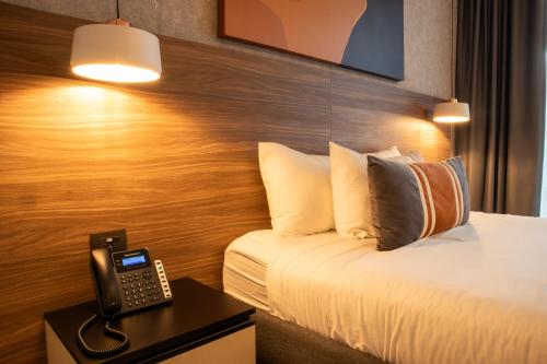 a hotel room with a bed and a phone on a table at Grand Hotel&Casino Vía Dorada in Pachuca de Soto