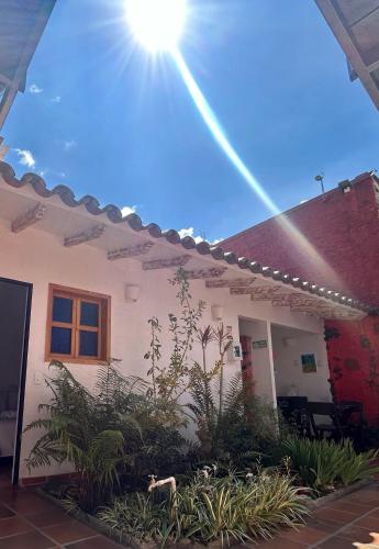a white house with the sun in the sky at Zana Hotel Boutique in Bogotá