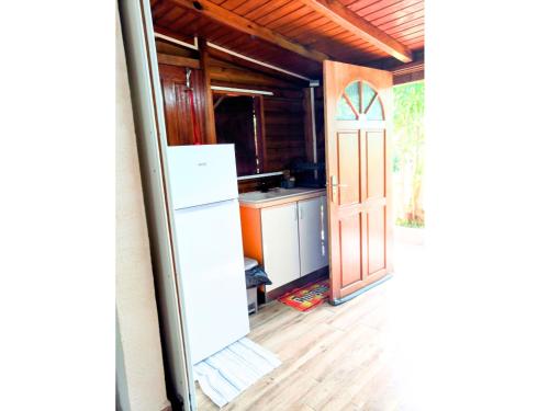 an open door to a kitchen with a refrigerator at L'Escapade Antillaise, T2 calme, proche de tout, jardin in Baie-Mahault