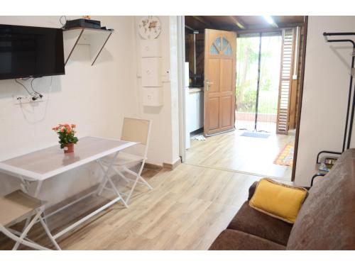 a living room with a white table and a couch at L'Escapade Antillaise, T2 calme, proche de tout, jardin in Baie-Mahault