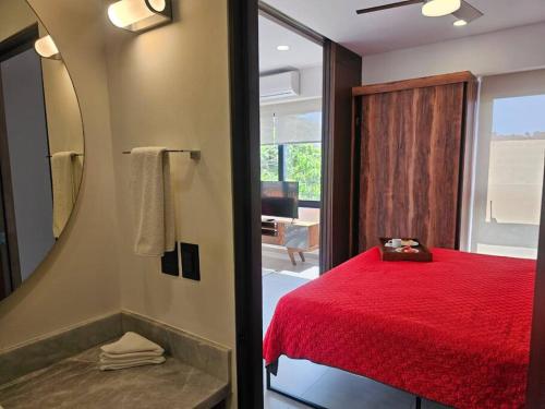 a bedroom with a red bed and a mirror at Estudio de ensueño con alberca 303 in Puerto Vallarta