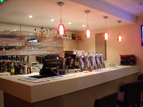 a bar in a restaurant with glasses on the wall at Logis-Hôtel & Restaurant LE CARNOT in Bolbec