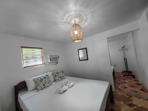 a white bed with two stuffed animals on top of it at 5R Tourist Inn & Restaurant in Pooc