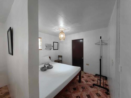 a bedroom with a white bed in a room at 5R Tourist Inn & Restaurant in Pooc