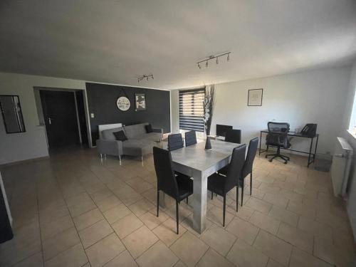 a dining room and living room with a table and chairs at Résidence iguanodon Maria in Bernissart
