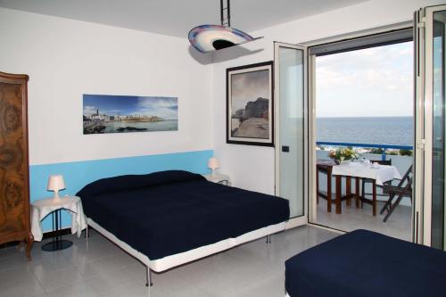sypialnia z łóżkiem i widokiem na ocean w obiekcie A Modo Mio B&B w mieście Monopoli