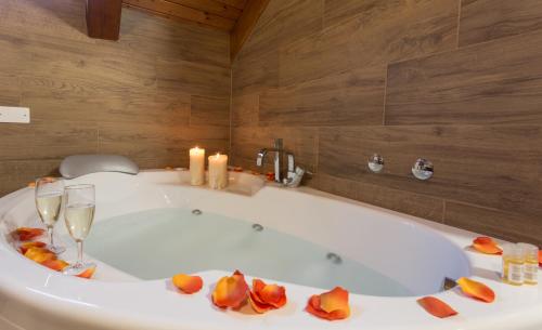 a bathroom with a tub with candles and wine glasses at Hotel La Baita in Malborghetto Valbruna