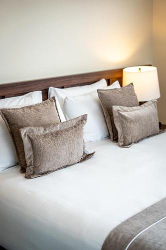 a bed with white pillows and a lamp on it at Newina Rotorua in Rotorua