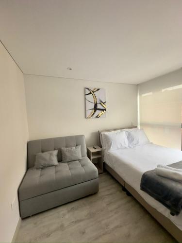una camera con un letto e un divano di Encanto y ubicación perfecta en Corferias a Bogotá