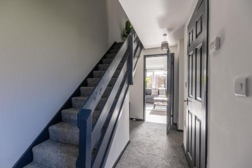 a staircase in a house with a blue wall at Modern 3 Bed House-Free Parking in Cramlington
