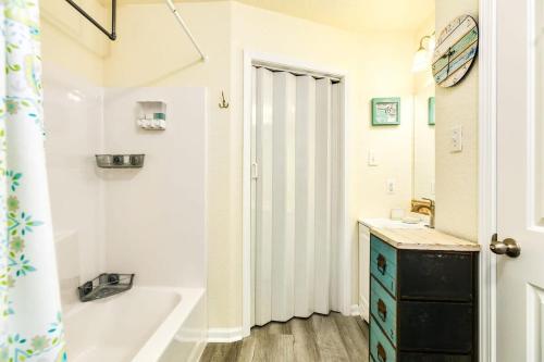 a white bathroom with a tub and a sink at Breathtaking Island Views from Multiple Decks! in Surfside Beach