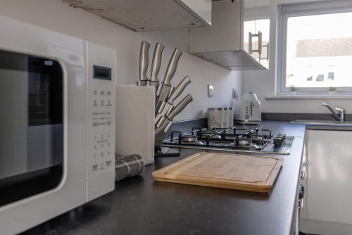 a kitchen with a stove top oven and a microwave at Modern 3 Bed House-Free Parking in Cramlington