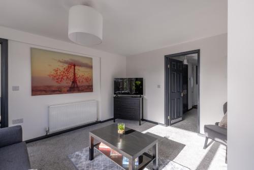a living room with a couch and a table at Modern 3 Bed House-Free Parking in Cramlington