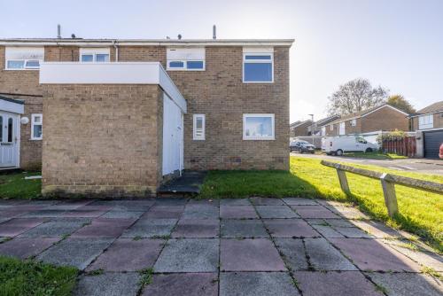 a brick house with a white door and a fence at Modern 3 Bed House-Free Parking in Cramlington