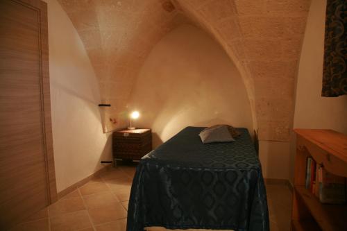 a small room with a green bed in a hallway at Il Casolare Degli Ulivi in Oria