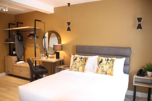 a bedroom with a bed and a desk and a mirror at Birdies Townhouse Mitchelstown in Mitchelstown