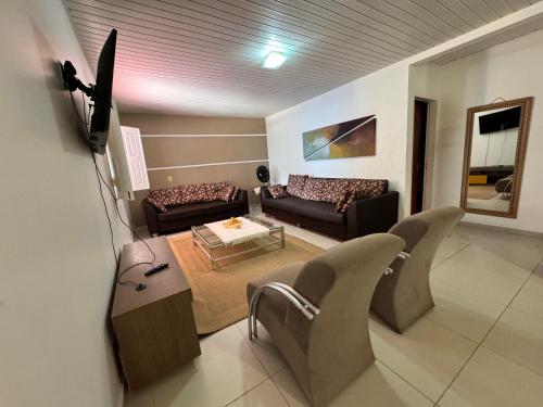 a living room with two couches and a tv at House Beach Canoa in Canoa Quebrada