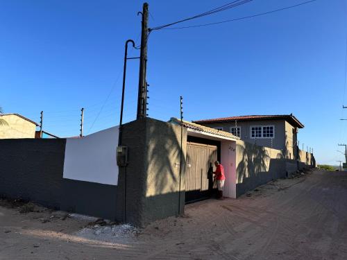 a woman standing in the doorway of a building at House Beach Canoa in Canoa Quebrada
