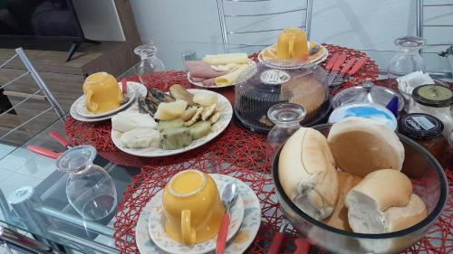 a table with plates of food on top at Casa simples Natal Luz e FIG in Garanhuns