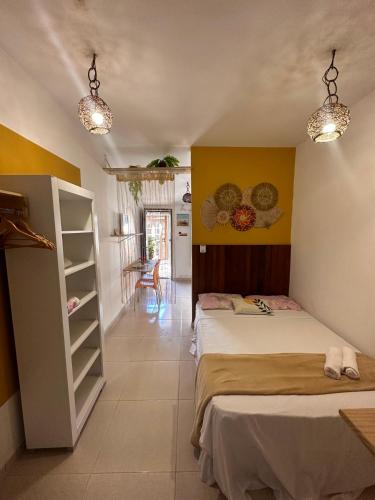 a bedroom with two beds and a yellow wall at Residencial Temporada Aracaju in Aracaju