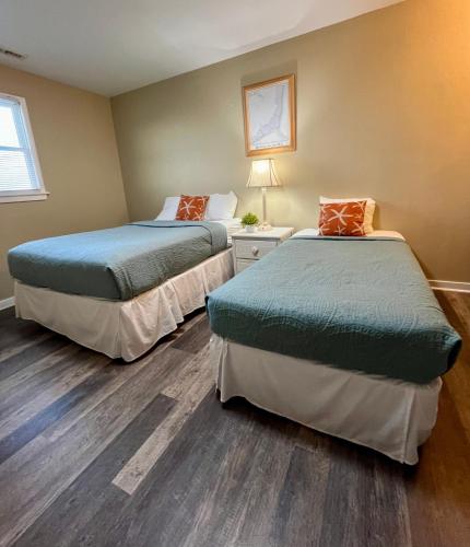 two beds in a room with wood floors at Cape Hatteras Motel in Buxton