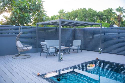 a patio with a table and chairs next to a pool at Yolena Villa in Le Gosier