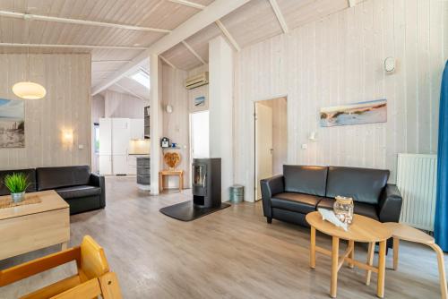 a living room with black leather furniture and a table at Strandblick - Dorf 1 Ferienhaus 09 in Priwall