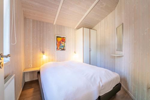 a bedroom with a white bed in a room at Strandblick - Dorf 1 Ferienhaus 09 in Priwall
