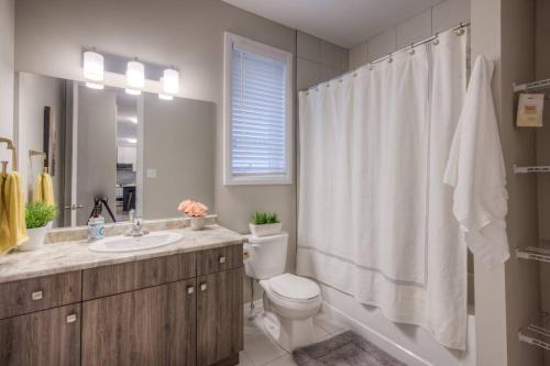 a bathroom with a toilet and a sink and a shower at BRAND-NEW LUXURY SUITE in DOON SOUTH, min to 401 in Kitchener
