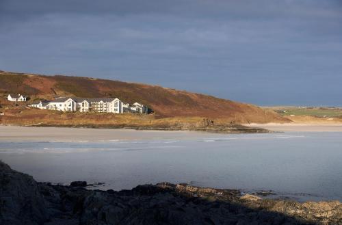 a group of houses on a hill next to a beach at Inchydoney Island Lodge & Spa in Clonakilty