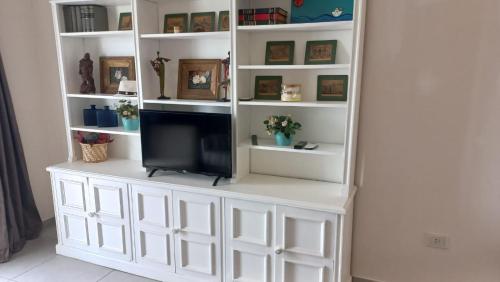 a white book shelf with a tv in it at Balcón del Paraná in Corrientes