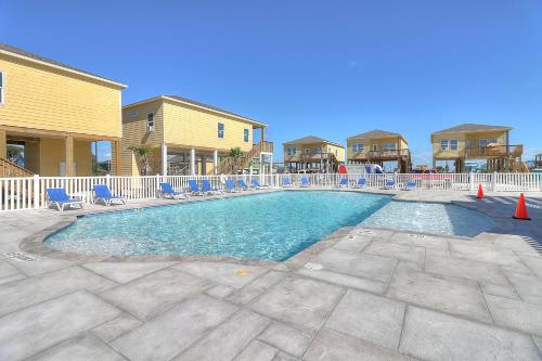 a swimming pool with blue chairs at Turtle Cove in Rockport