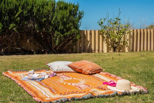 a blanket on the grass with hats and pillows on it at Shore Beats Work in Guilderton